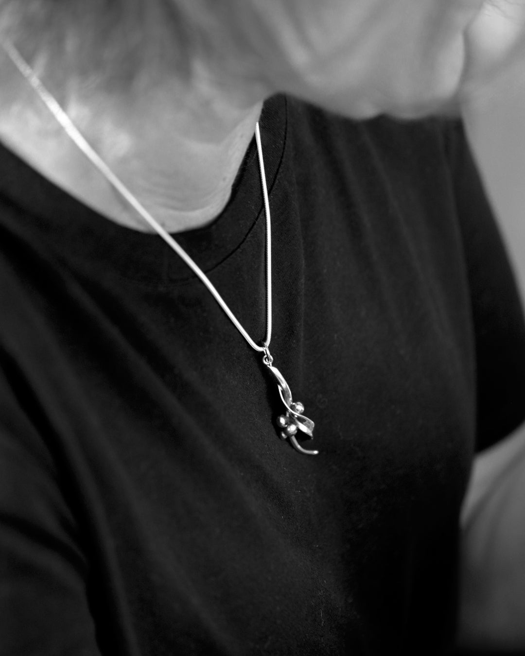 HAVTORN halsband in 925 sterling silver with a curved pendant on a black top