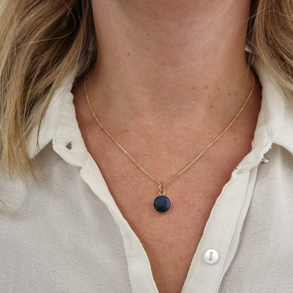 Round blue spectrolite pendant in 18K gold setting on a delicate chain