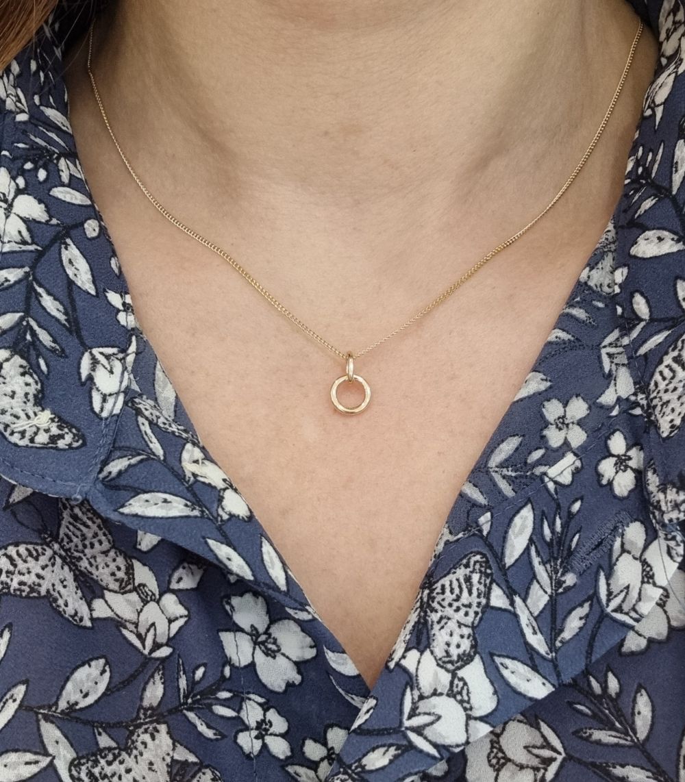 I HAMN LILLA 18K halsband med ringformad förtöjningsring i guld på tunn kedja mot halsen