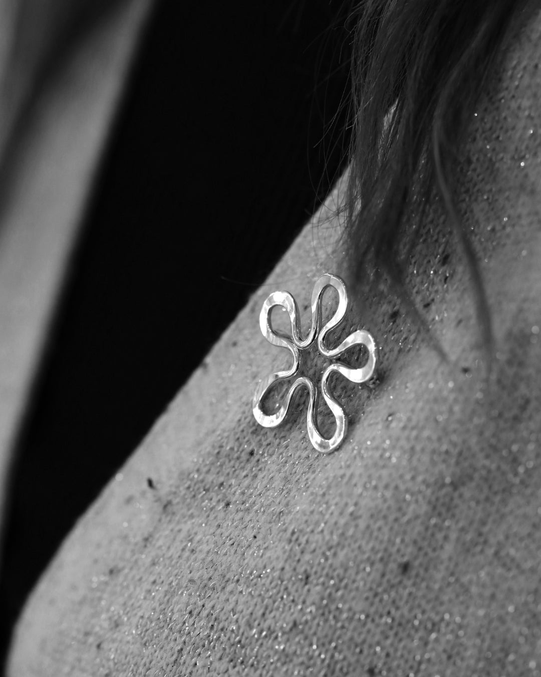 BLOMMAN L brooch in sterling silver with a six petal flower design worn on the shoulder