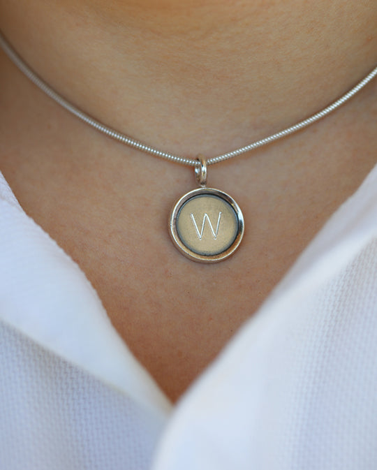 ALFA halsband i silver med bokstavsgravyr, buret på modell