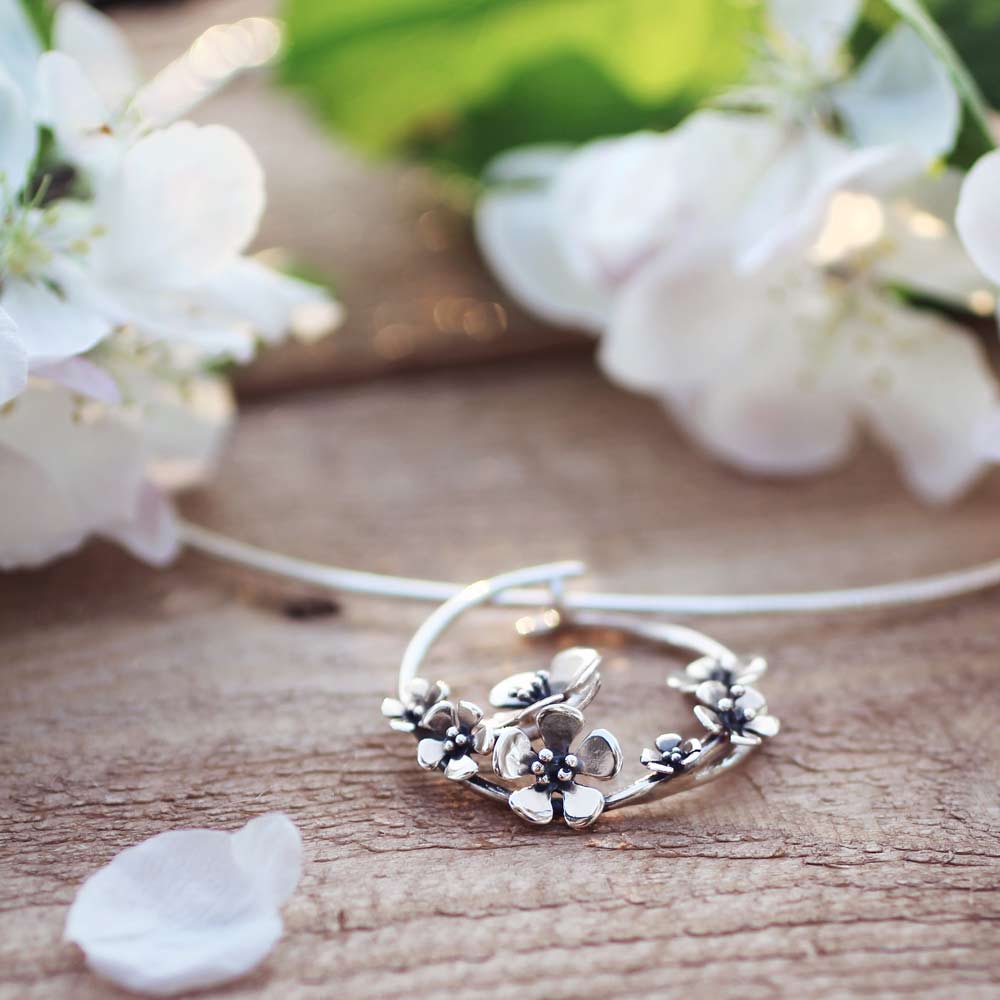 ÄPPELBLOM L halsband i 925 sterling silver med blomformigt hänge och en 42 cm ormkedja liggande på trä
