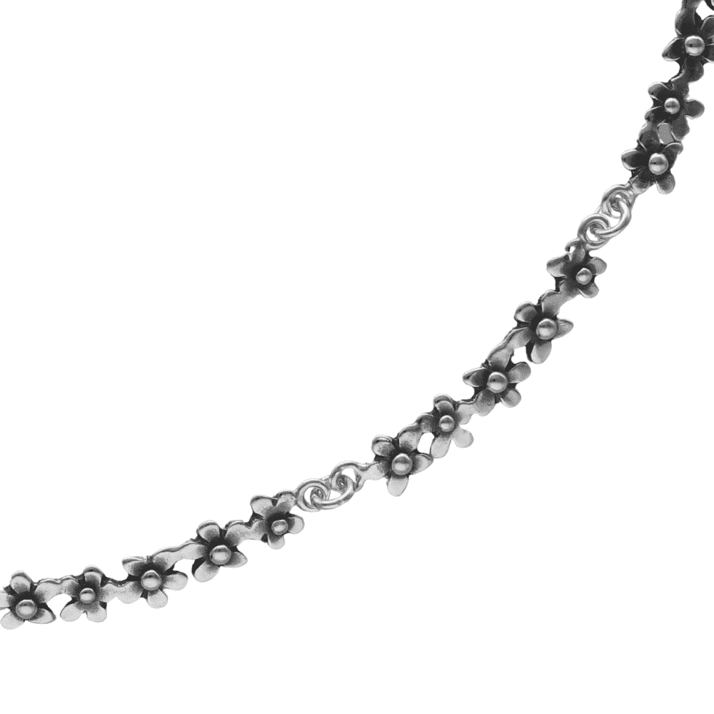 FÖRGÄT MIG EJ collier close up shows a silver flower chain necklace with tiny blossoms on white background.