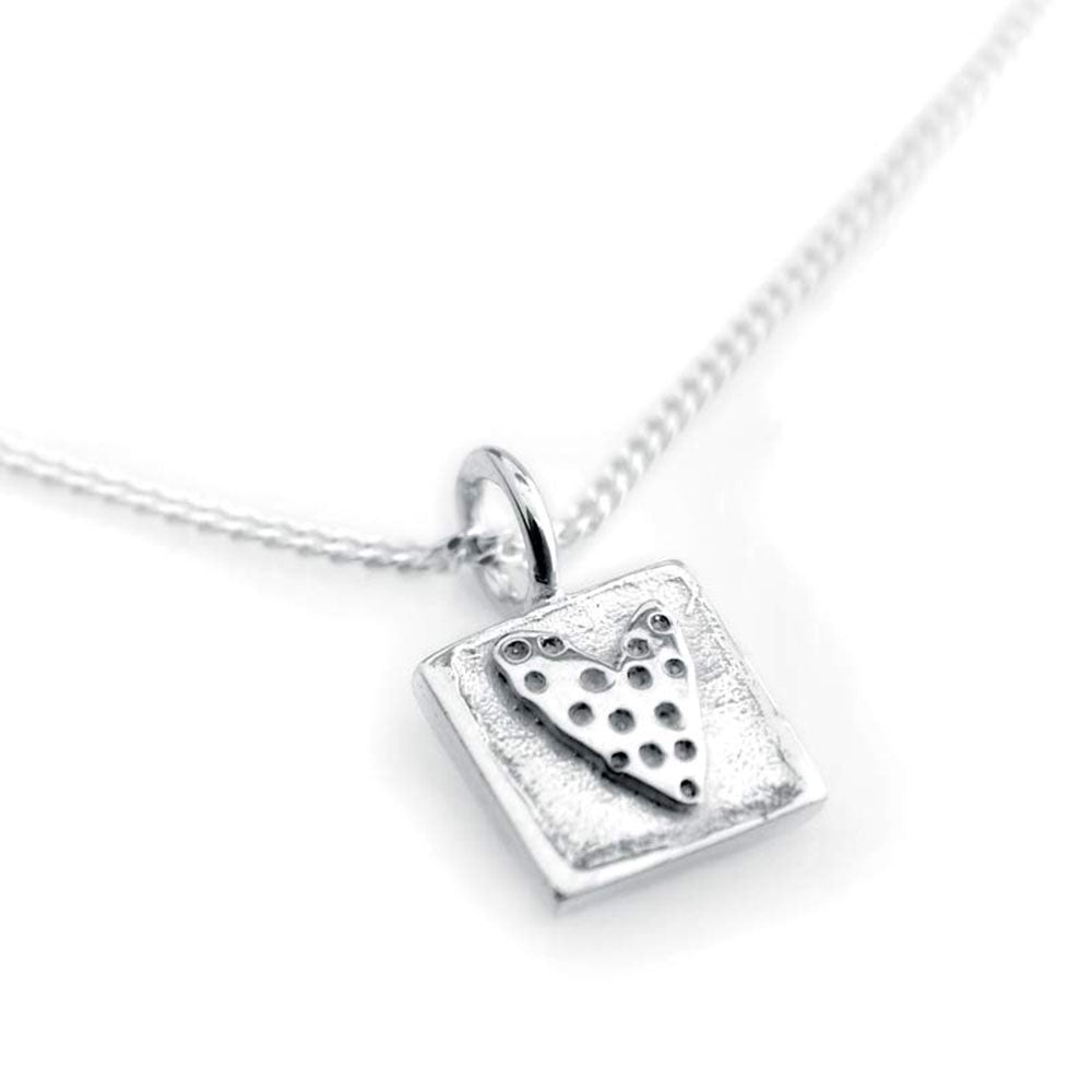 Square silver pendant with a perforated heart design on a delicate chain necklace
