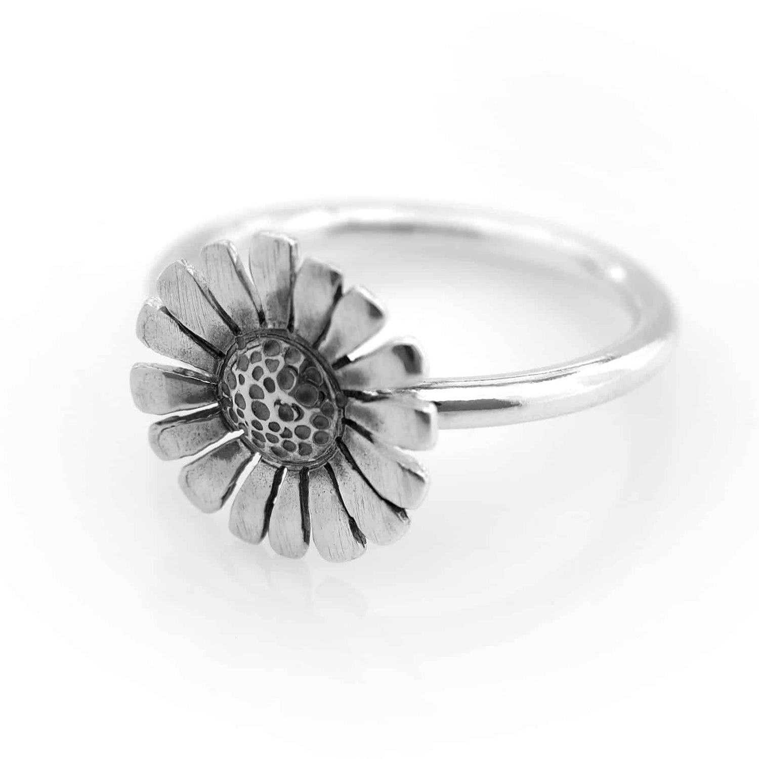 Silver daisy ring with flower shaped petals and a dotted center.
