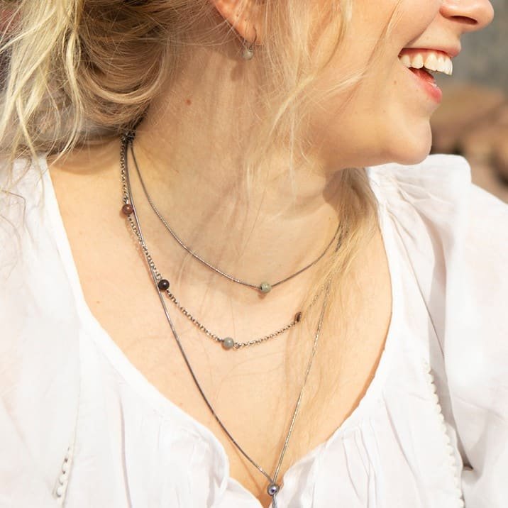 Layered STRAND Pärla halsband draped at the neck with multiple beads on two thin chains