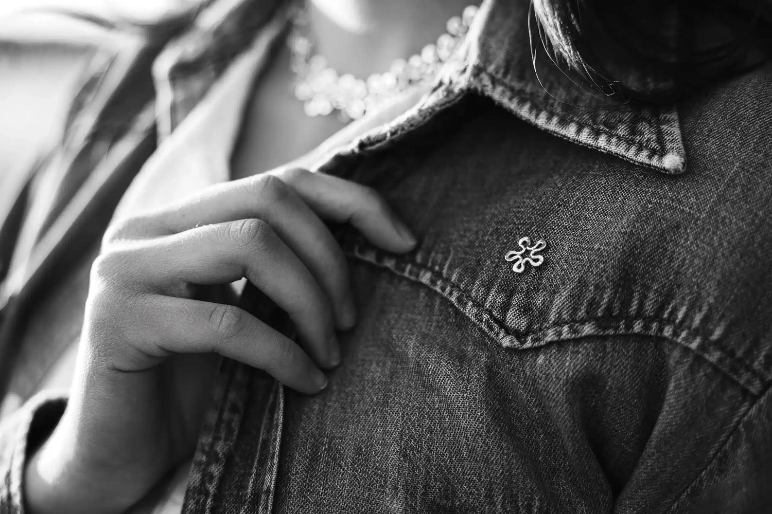 Flower shaped pin brooch on a denim jacket
