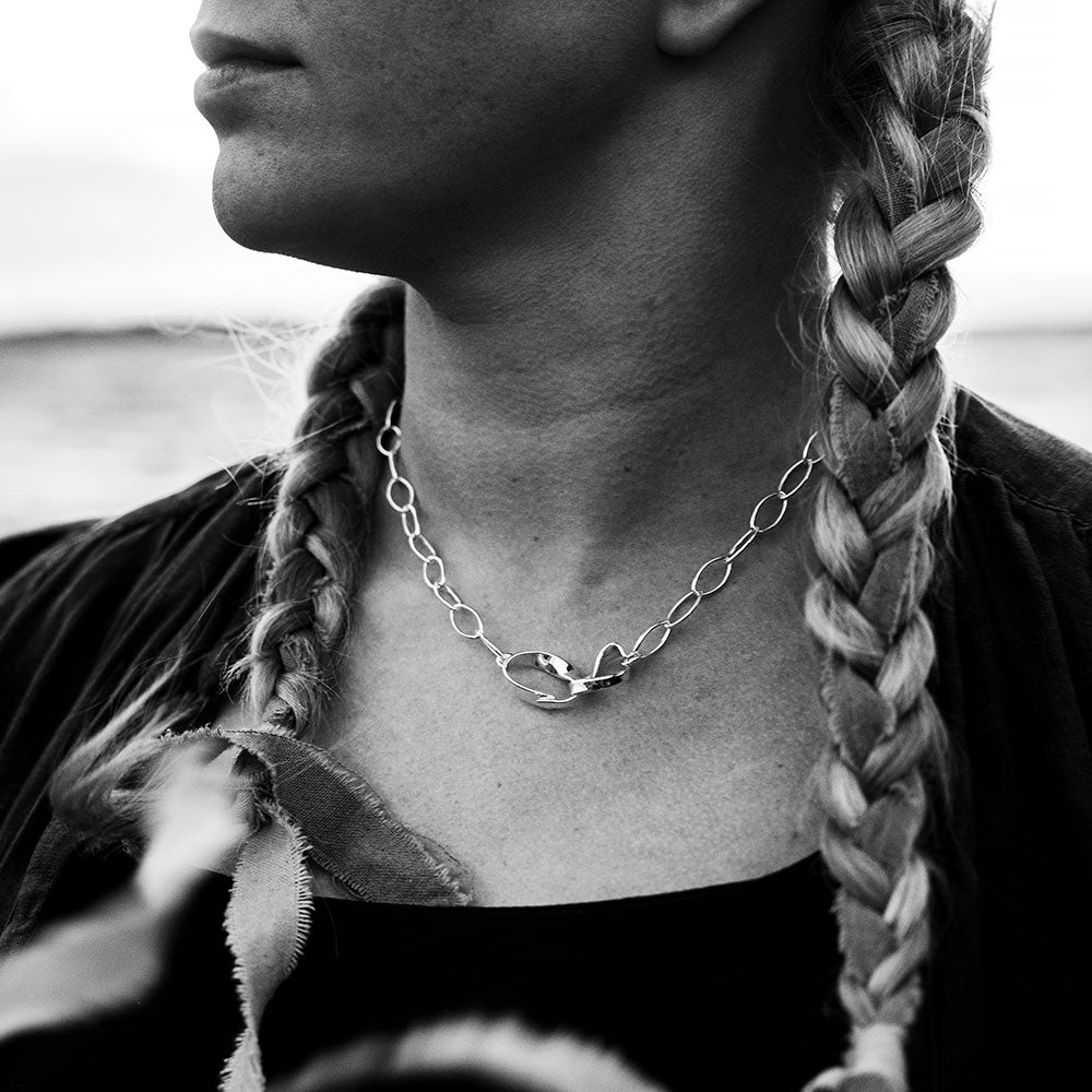 Woman wearing a sterling silver STORMSKÄRS MAJA NÄT necklace with large circular links and a bold central clasp.