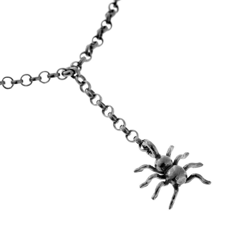 Close-up of a silver antique spider pendant on a chain necklace