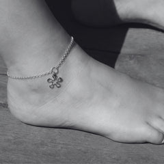 BLOMMAN XS vristlänk i sterlingsilver med blomformad berlock runt fotleden.