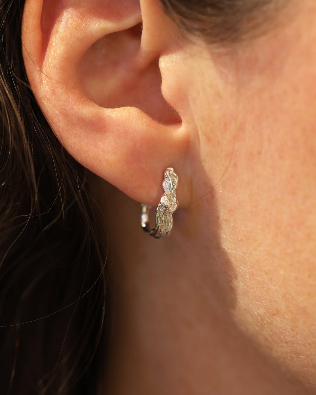 Sidovy av person som bär HAVET stiftörhängen i nickelfri 925 sterling silver med vågig form