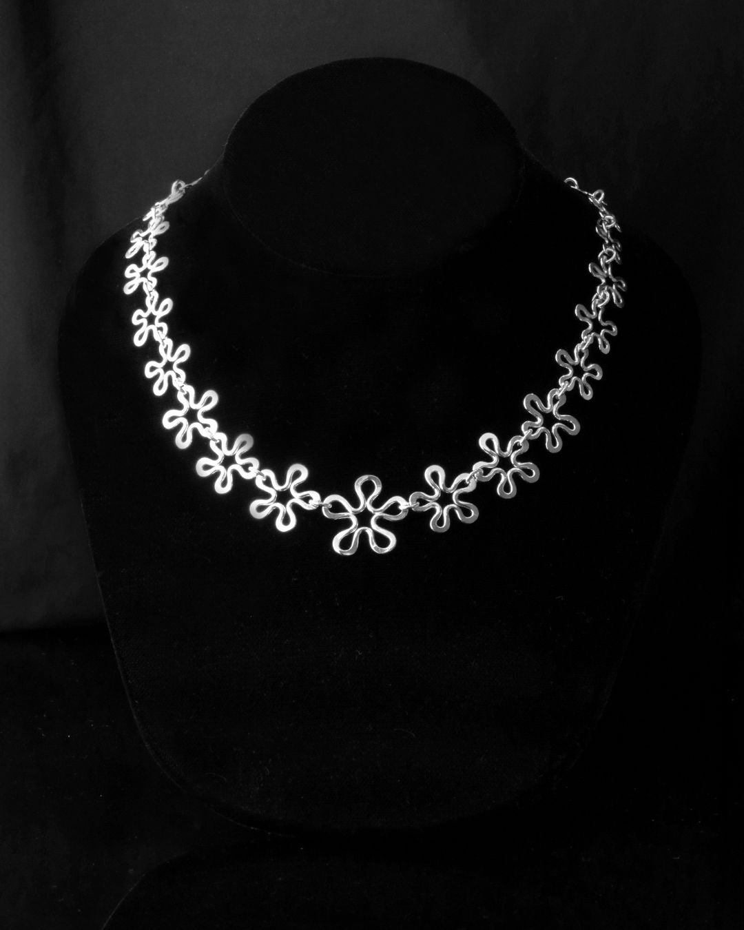 BLOMMAN Elegant necklace in silver with a continuous flower chain design on a black bust