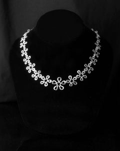 BLOMMAN Elegant necklace in silver with a continuous flower chain design on a black bust