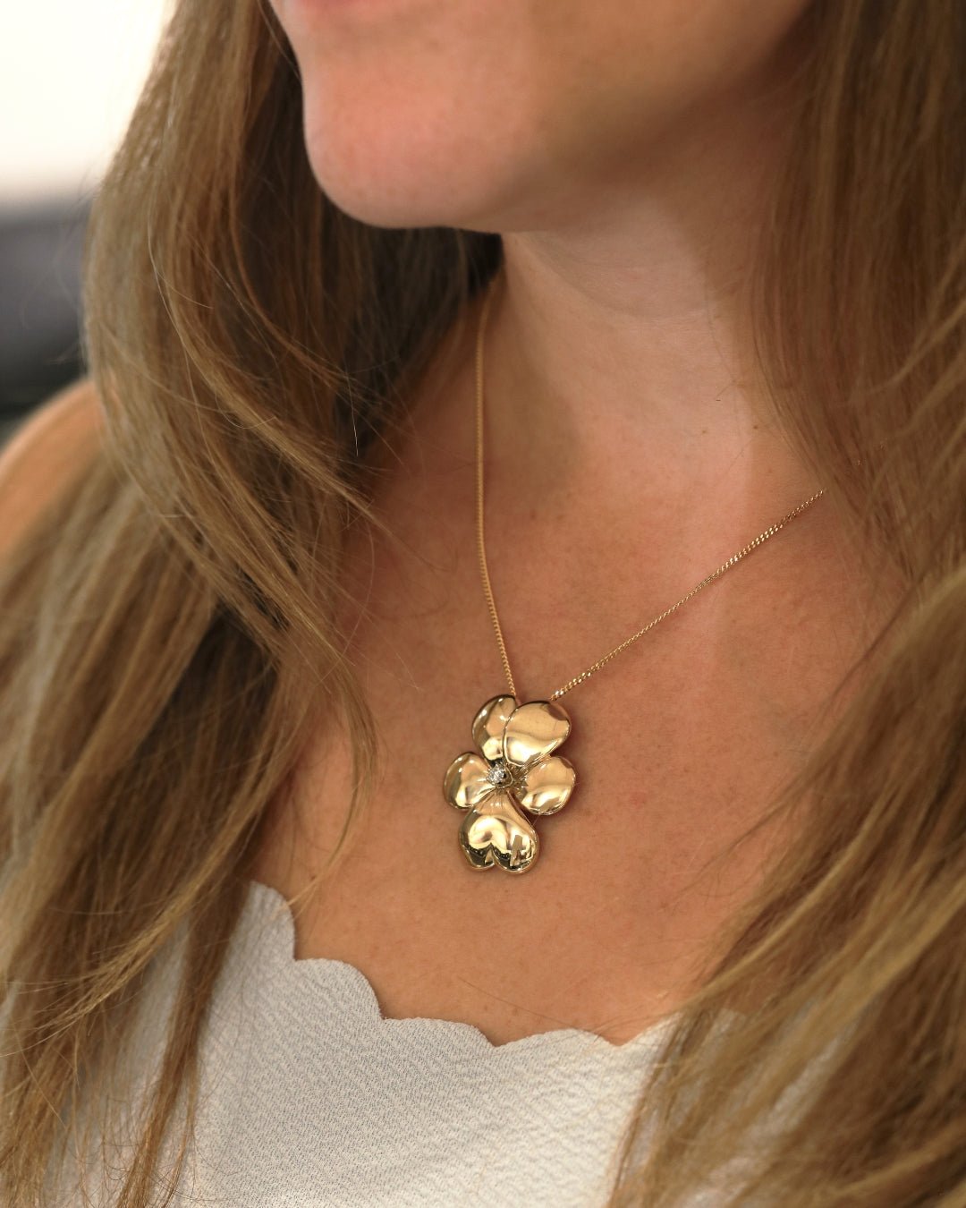 18K gold flower pendant necklace with a diamond centerpiece.