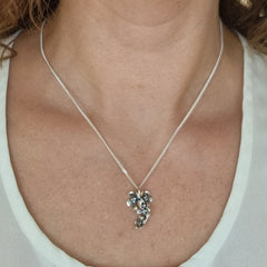 Silver halsband med blomsterhänge visas på modellens hals