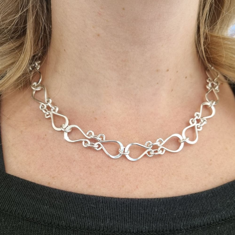 Närbild på en person som bär FOLKLORE halsband i silver runt halsen