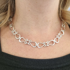 Närbild på en person som bär FOLKLORE halsband i silver runt halsen