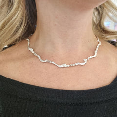 HAVET collier in 925 sterling silver resting on a model’s neck with a wavy textured chain inspired by stormy seas