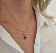 Model wearing Heart of Finland 18K gold necklace with blue spectrolite pendant