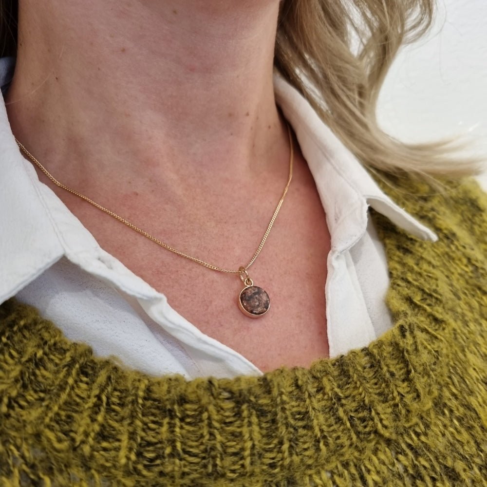 Round Åländsk red granite pendant set in 18K gold on a delicate chain