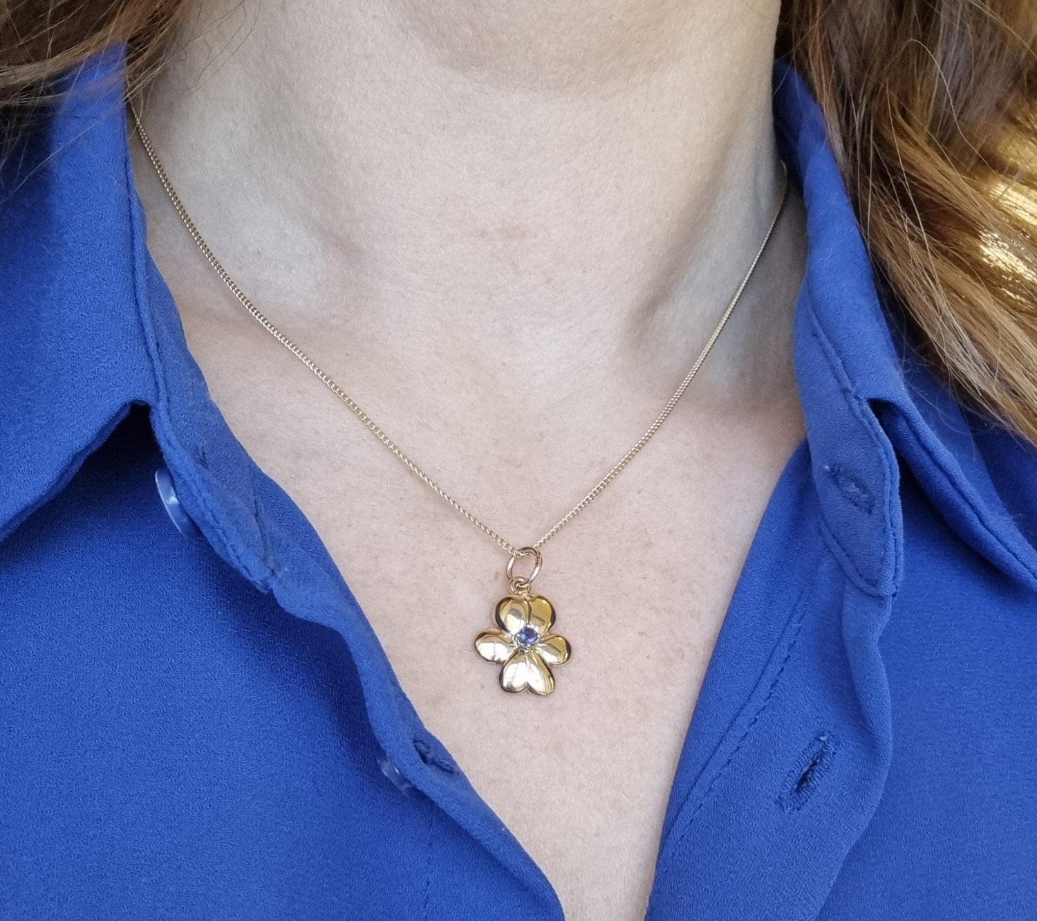 18K guld halsband med en violformad blom och finsk kordierit i mitten