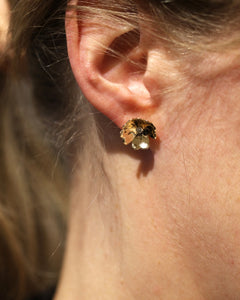 Öra med ett blomsterformat örhänge i 18K guld med diamant