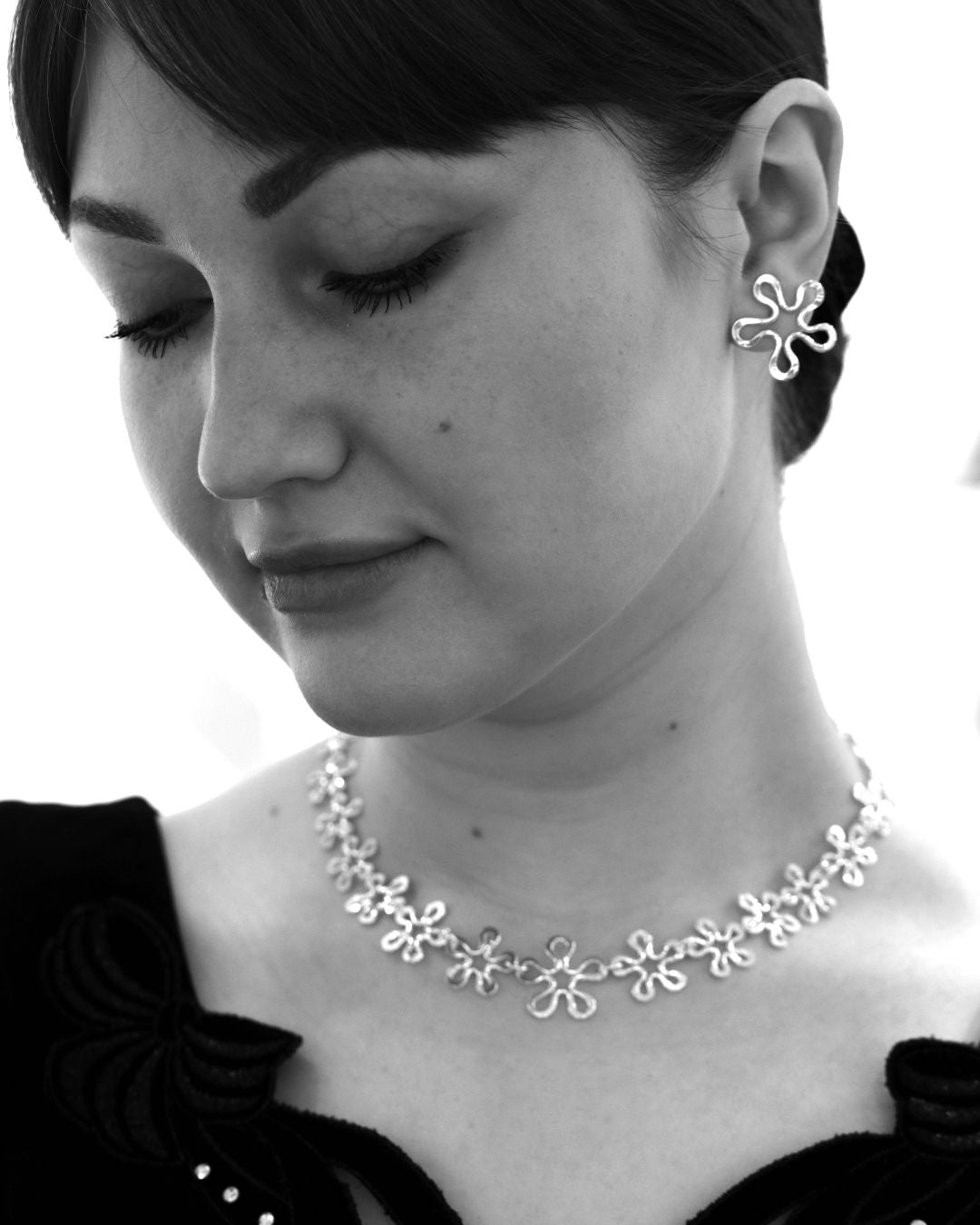 BLOMMAN Elegant collier i sterlingsilver med blomformade länkar bärs av en modell