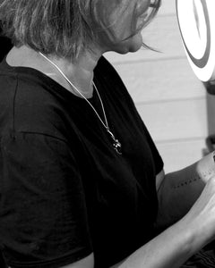 HAVTORN halsband in 925 sterling silver worn on a black shirt with the curved pendant visible