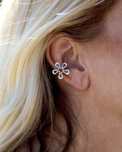 Sterling silver Blomman flower ear cuff worn on model's ear