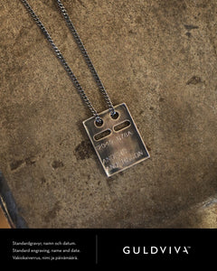 Antiqued silver rectangular ID tag pendant with two holes and engraved names on a chain.