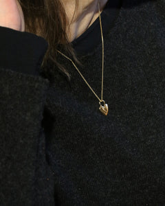 Modell bär ÄLSKA 18K halsband i guld med hjärtformat hänge runt halsen