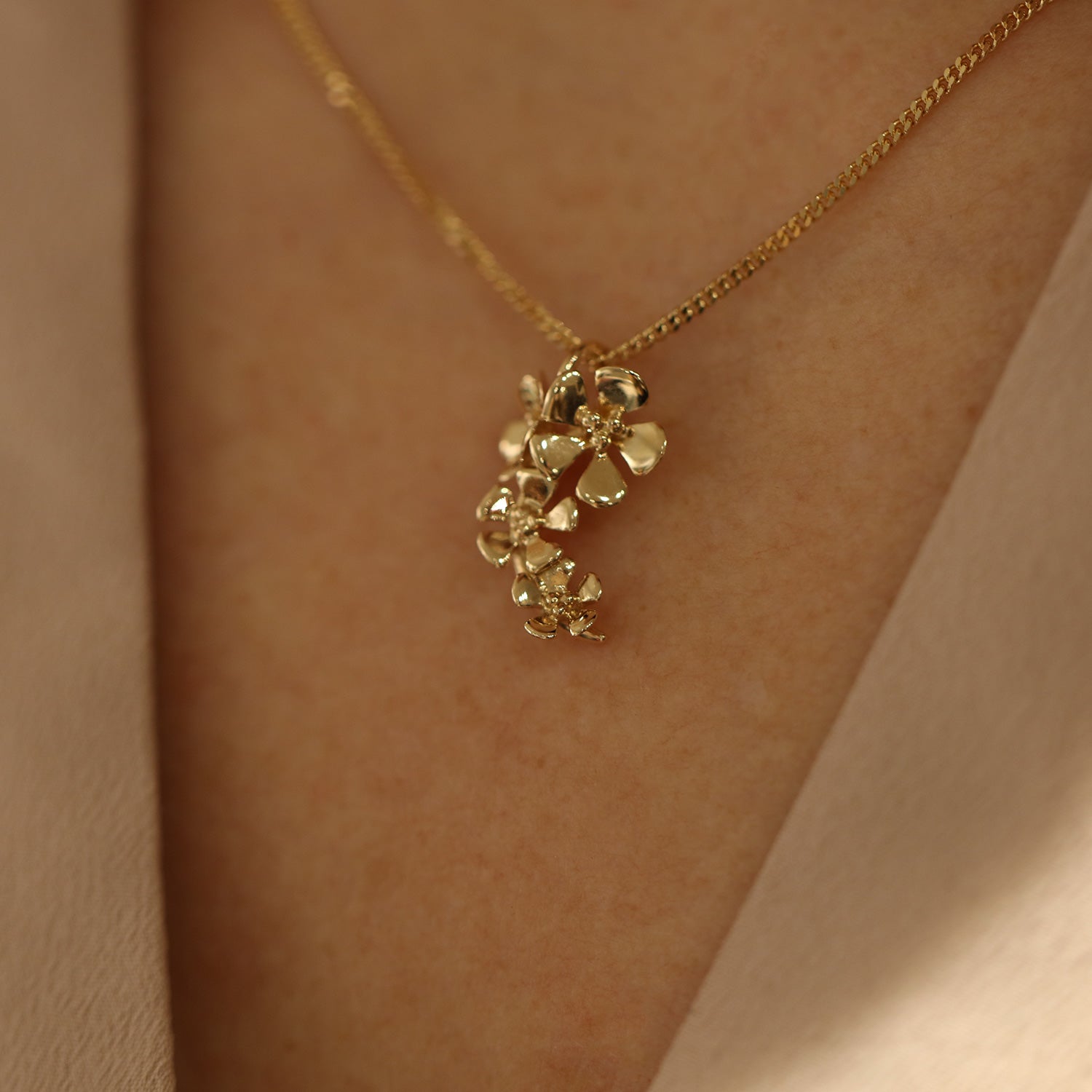 18K gold flower cluster pendant shown on a delicate chain