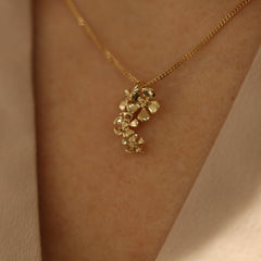 18K gold flower cluster pendant shown on a delicate chain