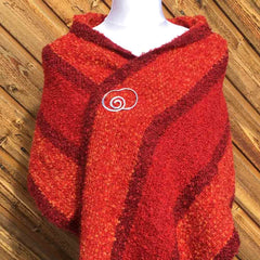 Red textured knit scarf styled with a silver spiral brooch
