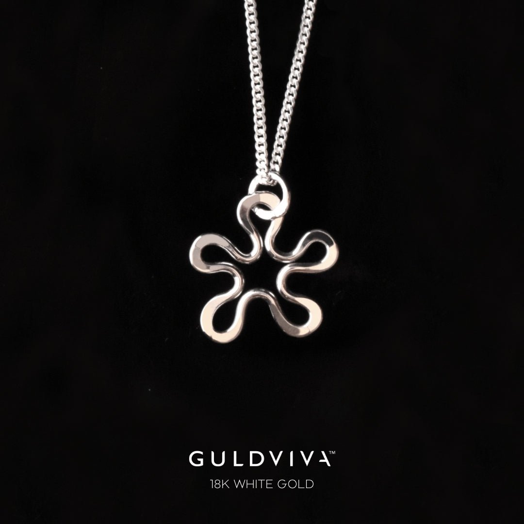 Blomman 18K white gold flower pendant on chain against black background