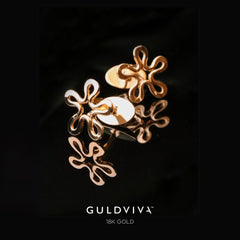 BLOMMAN 18K guld manschettknapp med blomformad design på mörk spegelblank yta