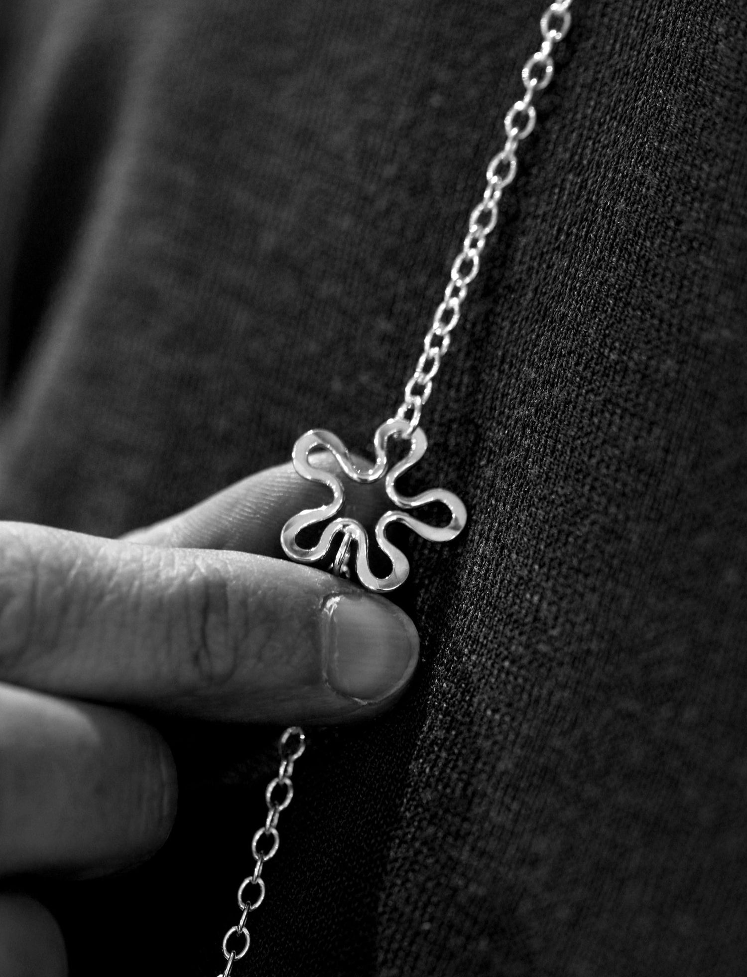 Närbild av blomformigt hänge på BLOMMAN kedja halsband i silver