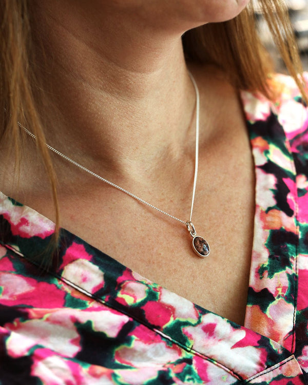 Oval red granite pendant in a silver bezel on a silver chain