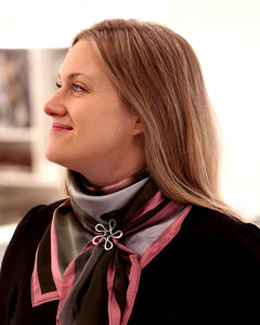 Model wearing BLOMMAN L Scarfring on a scarf, silver flower clasp