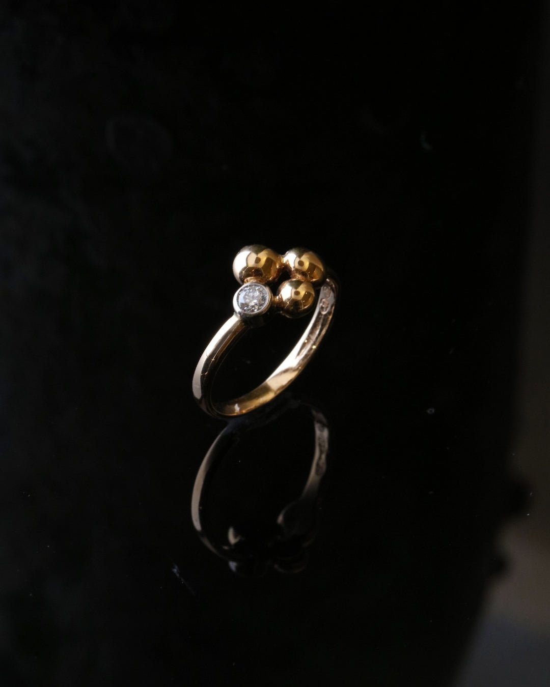 Celebrate ring in 18K gold featuring a small 0.10 ct diamond and a cluster of gold beads