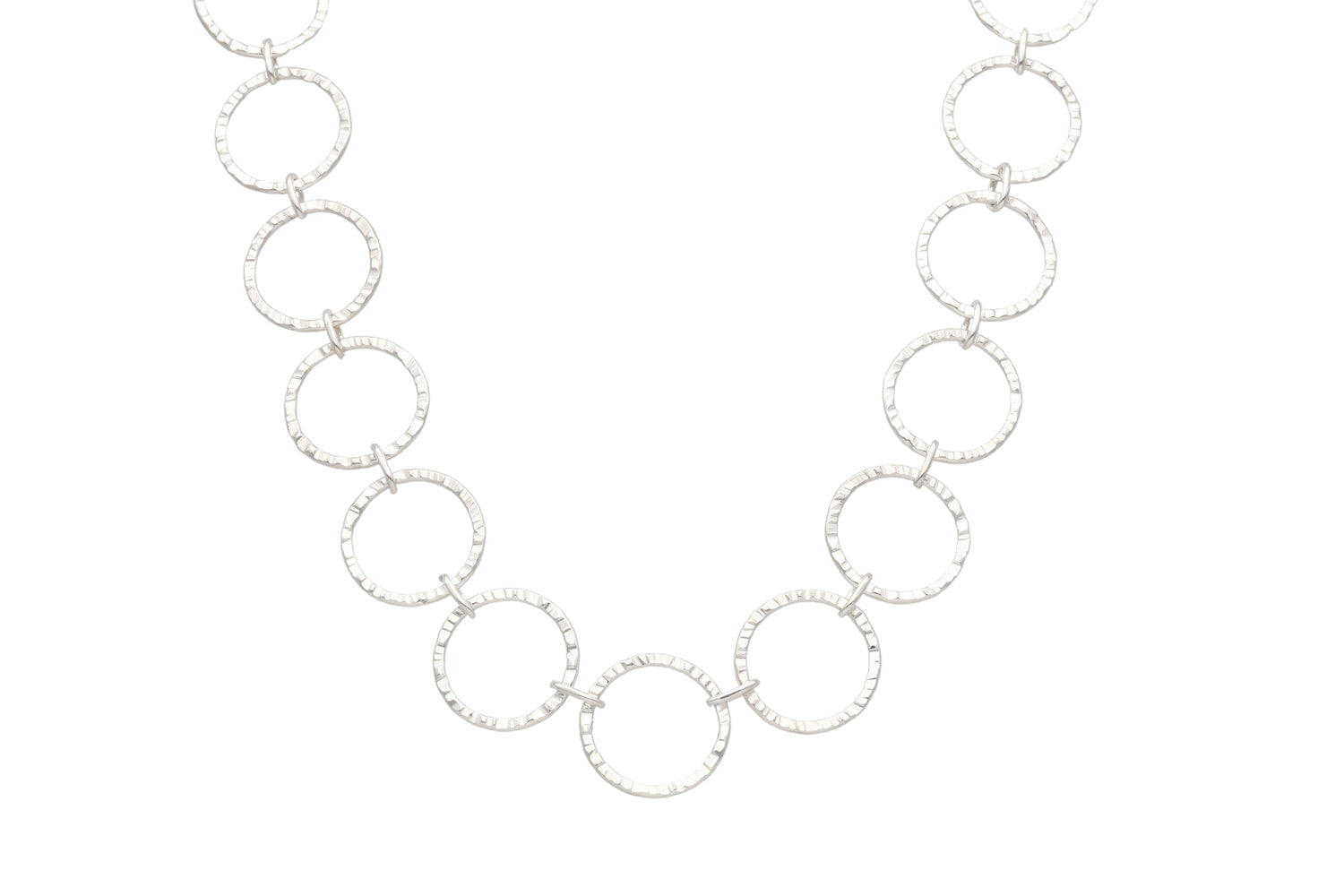 CIRCLA necklace in hammered circular links sterling silver laid flat against white background
