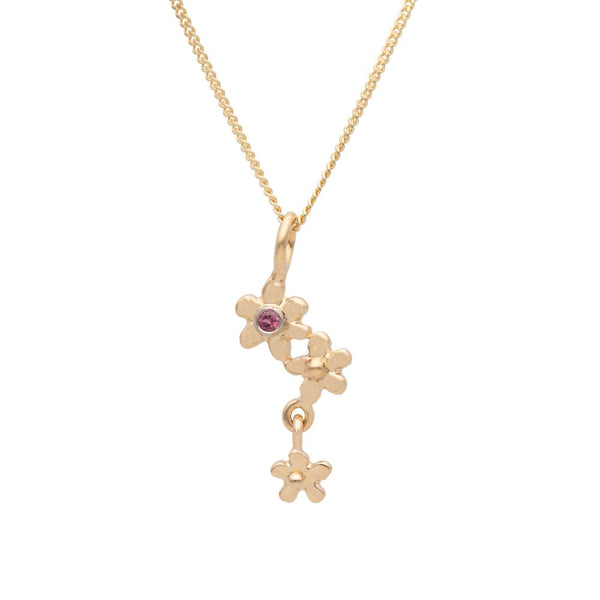 18K gold necklace featuring a cluster of forget-me-not flowers with a central garnet and a small dangling blossom