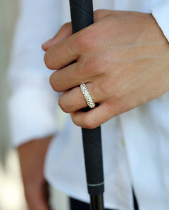 GOLF ring i silver på hand som håller ett golfgrepp