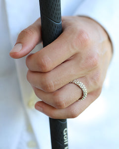GOLF ring i silver på hand som håller ett golfgrepp