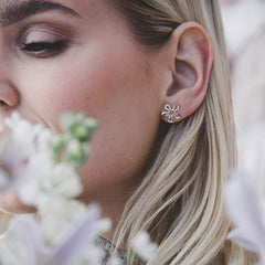 Närbild av person som bär BLOMMAN örhängen på stift i silver