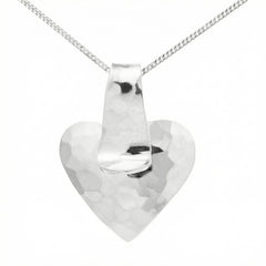 HAMRAT HJÄRTA halsband hammered heart pendant on a 42 cm chain worn by model in a white shirt