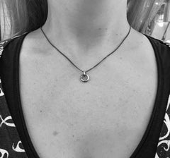 Person bär halsband med förtöjningsring i antikbehandlad silver på tunn kedja
