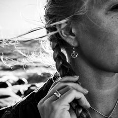 Örhänge med öppet hjärta i sterlingsilver på krok bärs av person med flätat hår