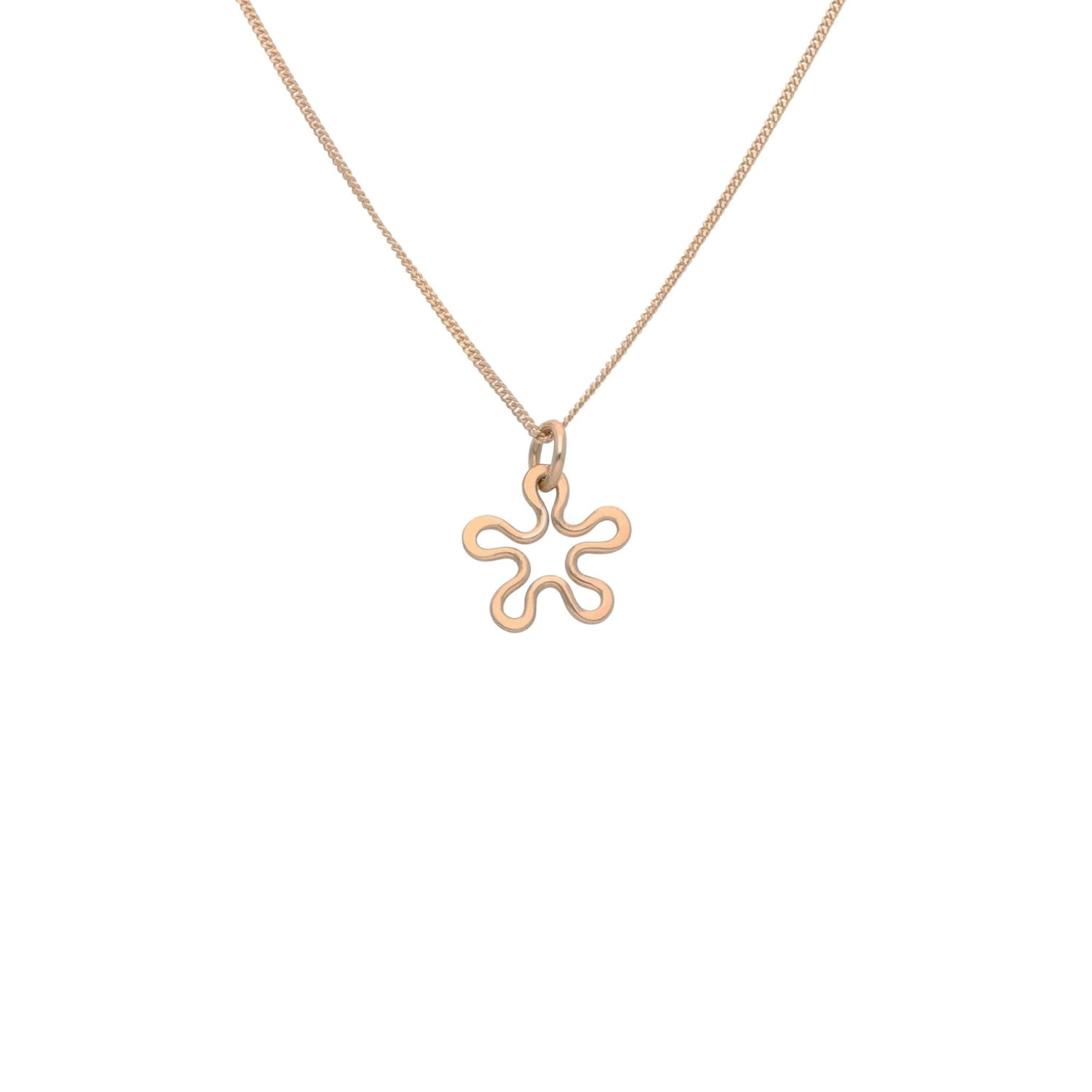 BLOMMAN 18K halsband med blomformad hängsmycke i roséguld som bärs av en person i blå blus
