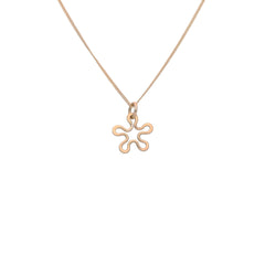 BLOMMAN 18K halsband med blomformad hängsmycke i roséguld som bärs av en person i blå blus